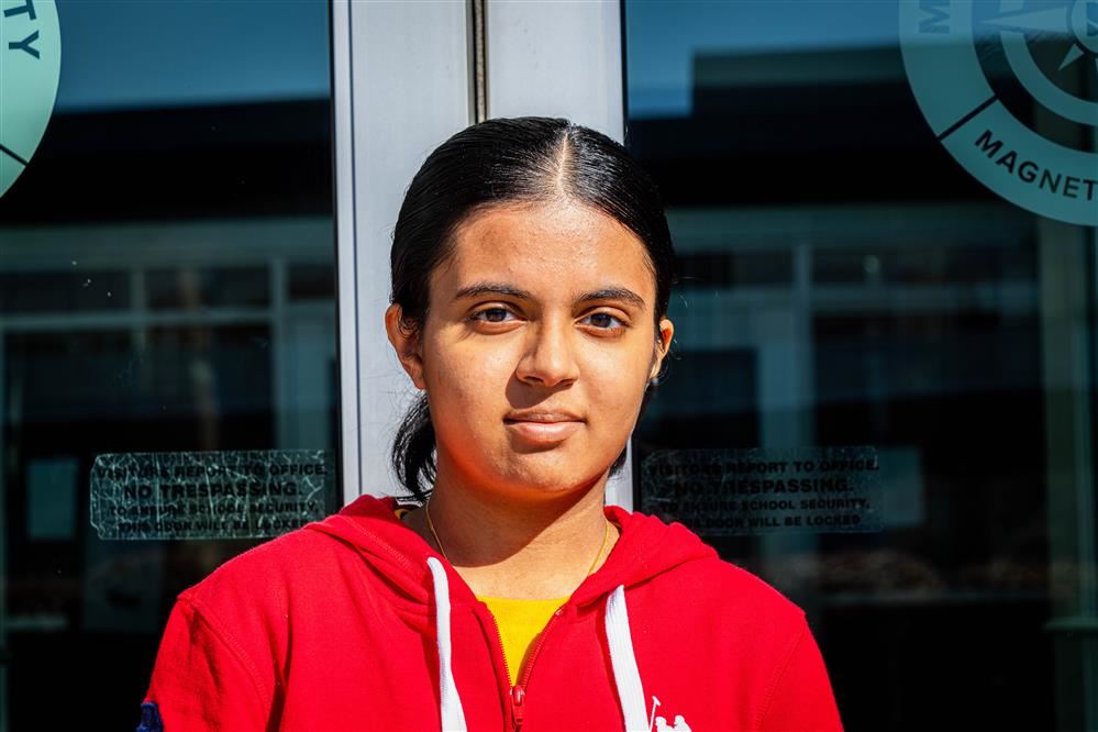  Student poses for picture in front of school